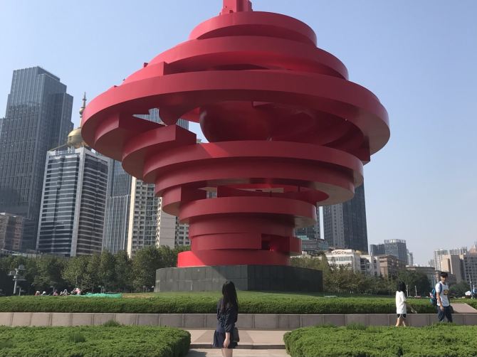 가을 날의 5.4광장. 5.4광장은 파란 하늘과 큰 건물들 . 트립닷컴 칭다오 트립 가이드.